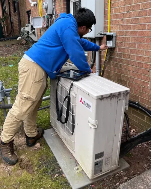 A Leonard Splaine technician servicing a Mitsubishi ductless outdoor unit