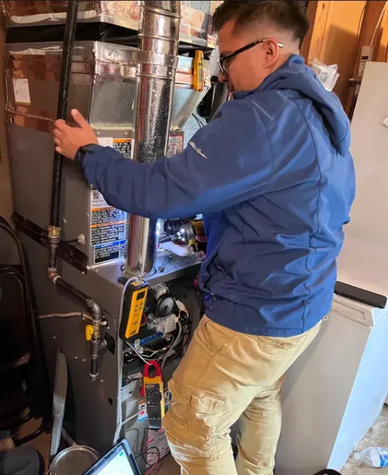 A Leonard Splaine technician working on a furnace during a no-heat call