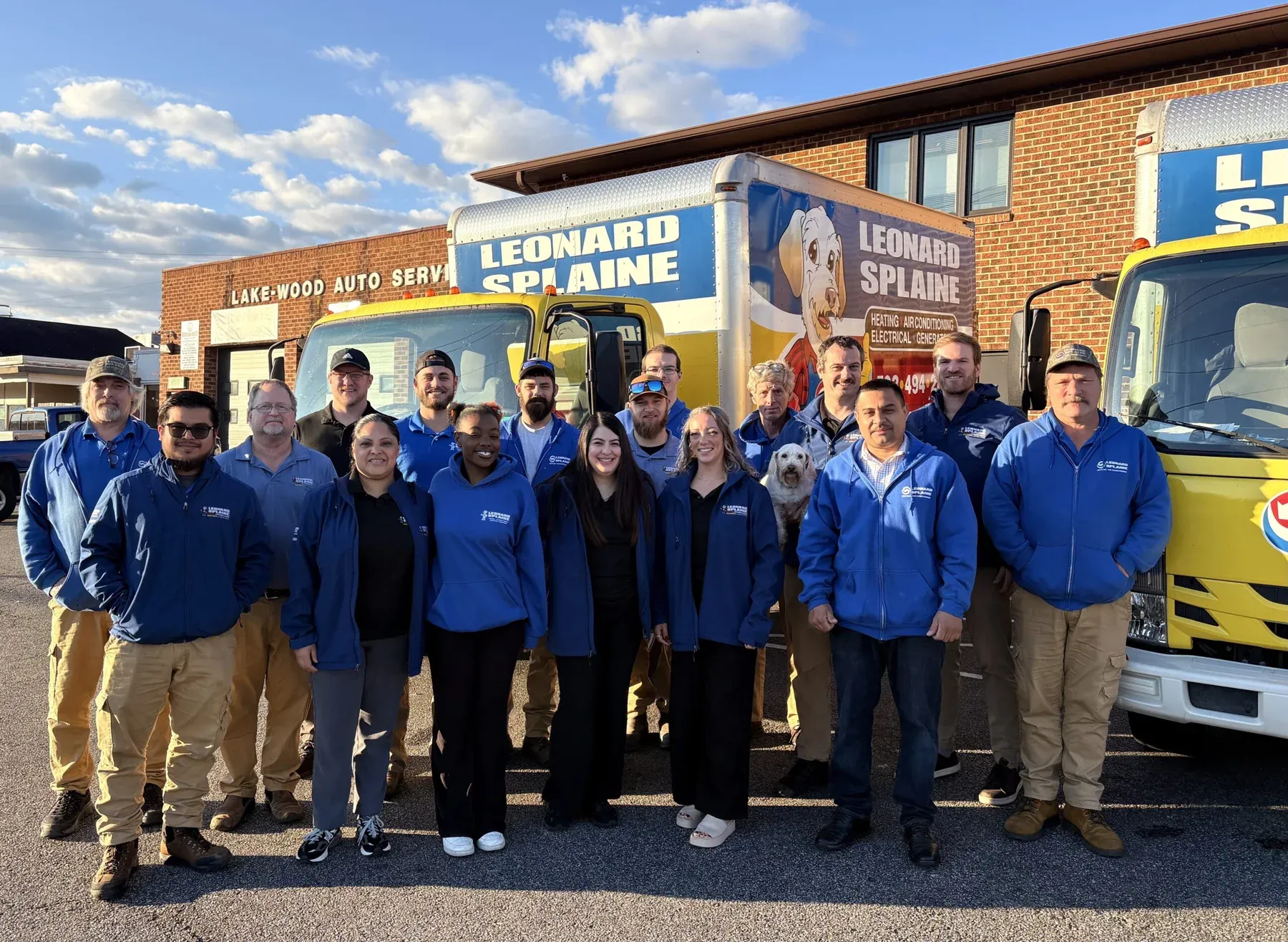 The Leonard Splaine team and Sonny the company dog in front of the fleet