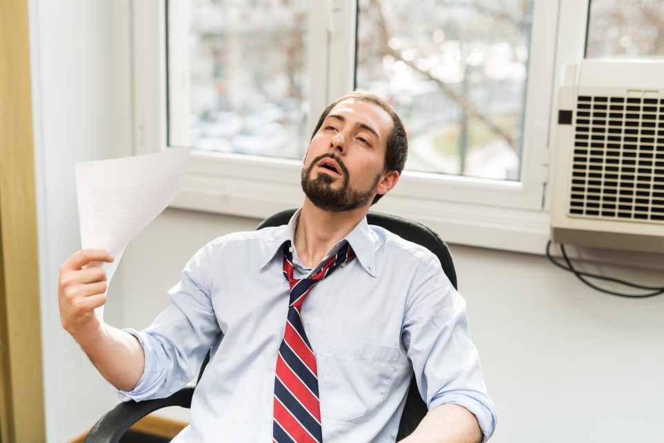 Man fanning himself with a sheaf of paper