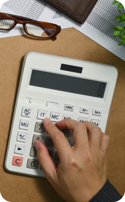 Hand pressing buttons on calculator for financial cost estimation.